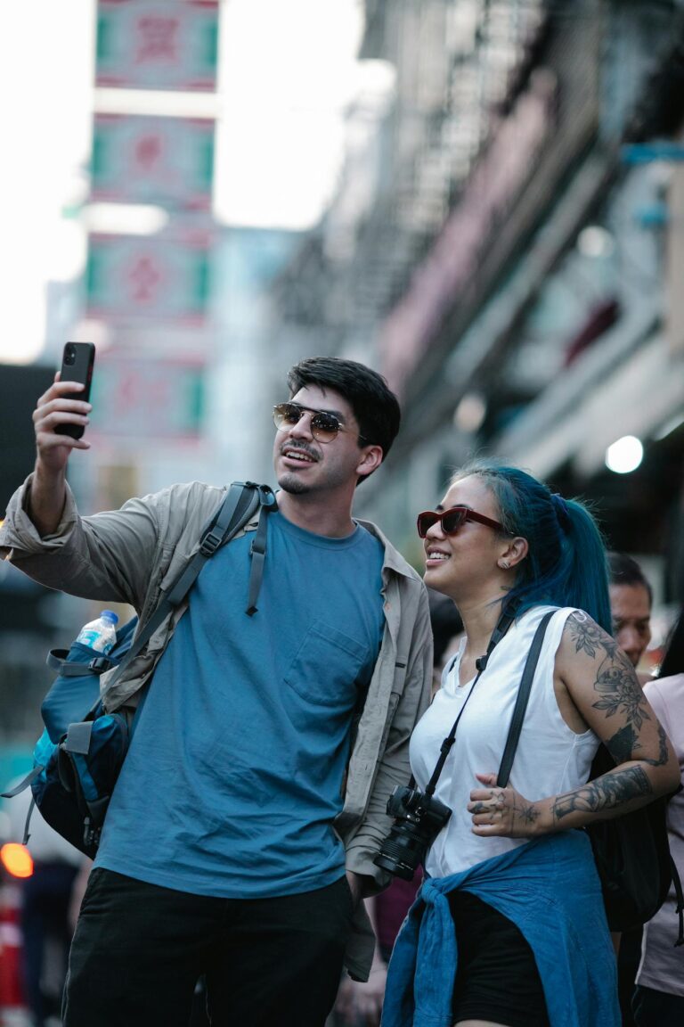 Happy tourists capture a moment on a bustling city street using a smartphone.